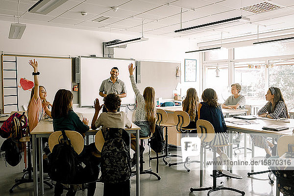 Männliche und weibliche Studenten mit Lehrer im Klassenzimmer