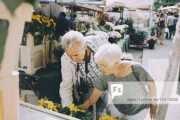 Älteres Ehepaar kauft im Urlaub Blumen auf dem Markt in der Stadt