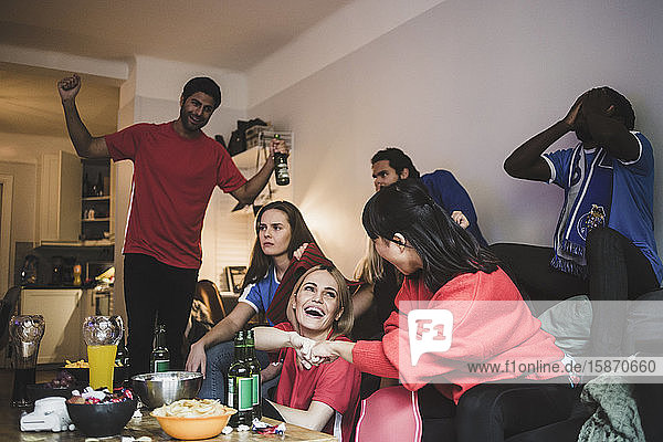 Fröhliches rotes Team feiert  während das blaue Team enttäuscht zu Hause sitzt