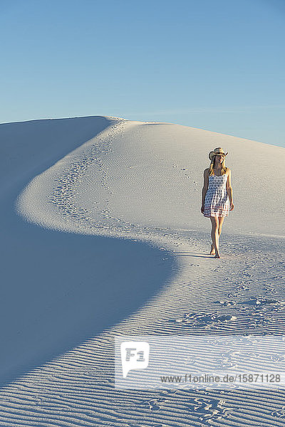 Eine Frau geht entlang der S-Kurve eines Dünenkamms im White Sands National Park  New Mexico  Vereinigte Staaten von Amerika  Nordamerika