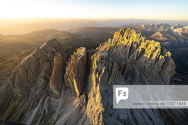 Aerial view of Sassolungo and Sassopiatto lit by the warm autumn sunset Val Gardena Val di Fassa Dolomites South Tyrol Italy Europe