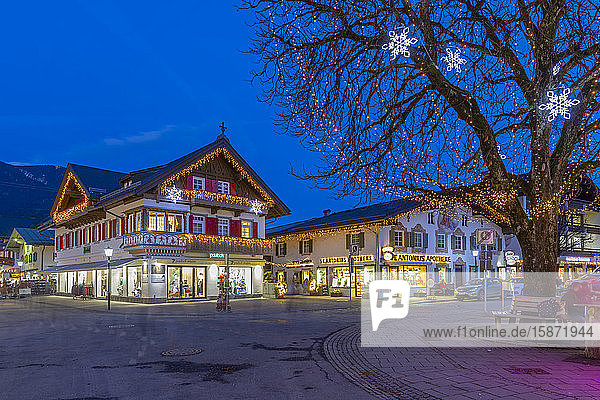 Blick auf lokale Geschäfte in der Stadt in der Abenddämmerung  Garmisch-Partenkirchen  Bayern  Deutschland  Europa