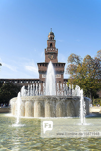 A fountain in front of the Torre del Filrete clock tower on the Castello Sforzesco Milan Lombardy Italy Europe