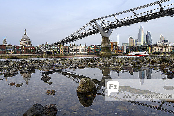 Millennium Bridge and city overview at low tide on River Thames  London  England  United Kingdom  Europe