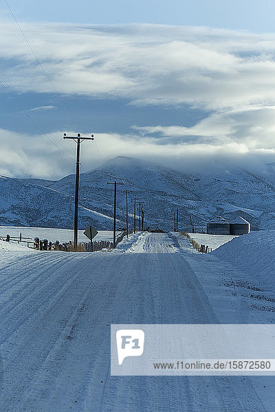 Snowy road with mountains in distance