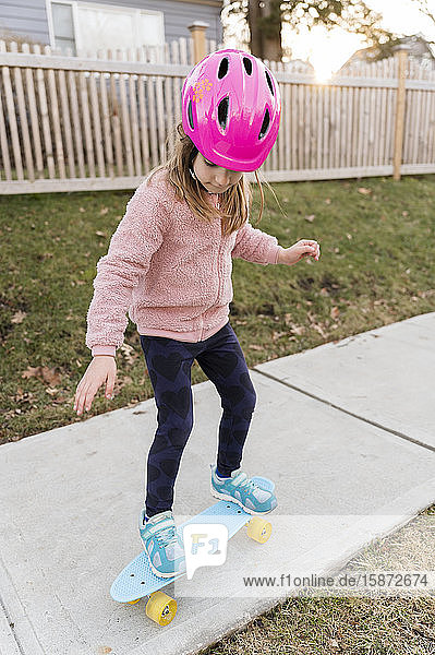 Girl skateboarding down a sidewalk