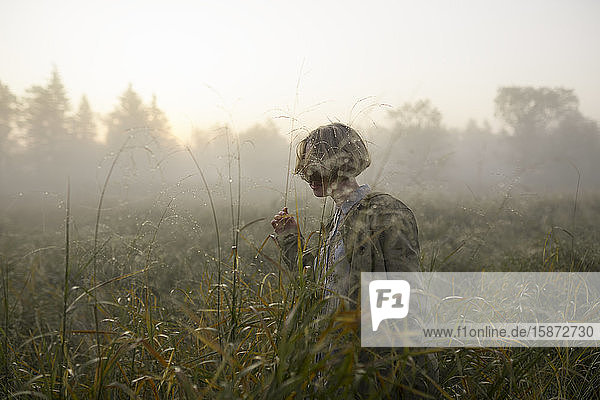 Junge Frau in einem Feld mit langem Gras