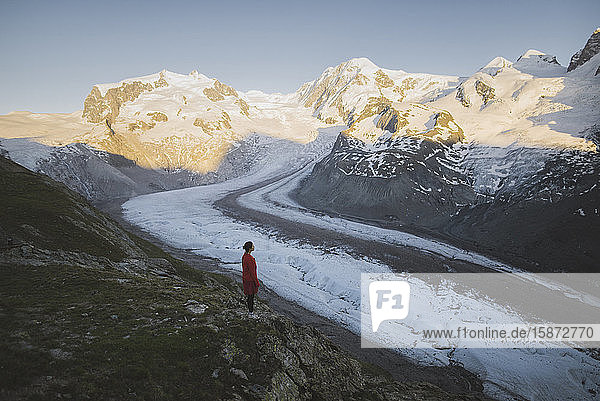 Frau steht auf einem Felsen am Gornergletscher im Wallis  Schweiz