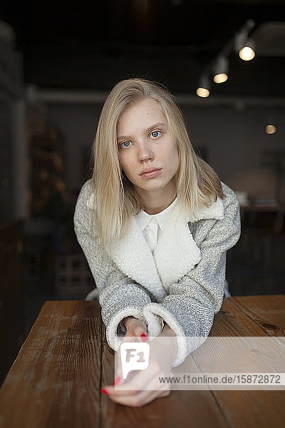 Junge Frau sitzt am Cafétisch