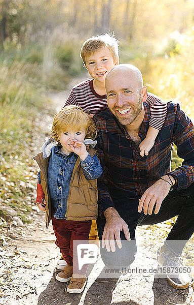 Smiling man with his sons on forest trail