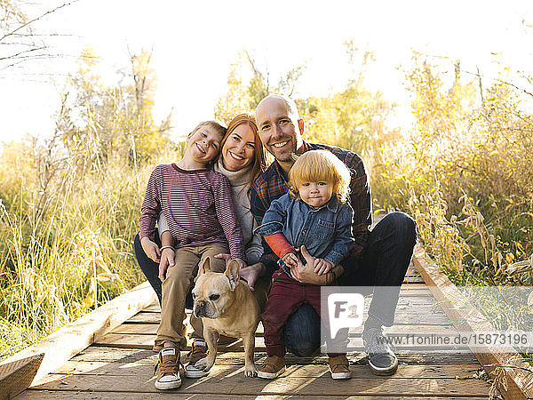 Lächelnde Familie auf der Waldpromenade