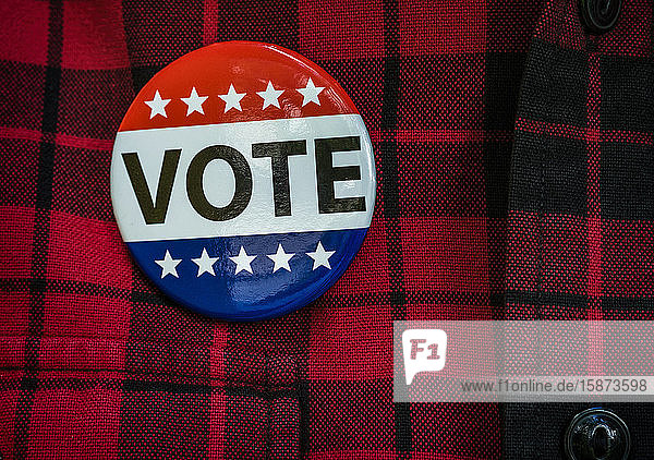 Vote button on red checked shirt