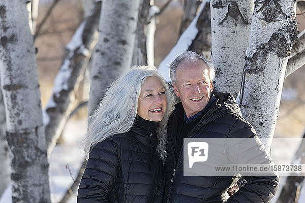 Smiling senior couple by tree