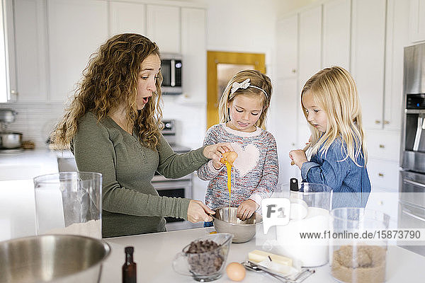 Frau backt Kekse mit ihren Töchtern