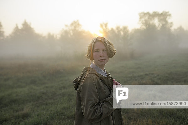 Young woman in field at sunset