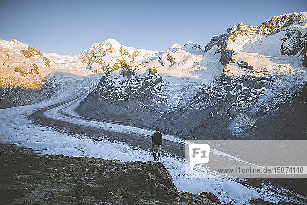 Mann steht auf einem Felsen am Gornergletscher im Wallis  Schweiz