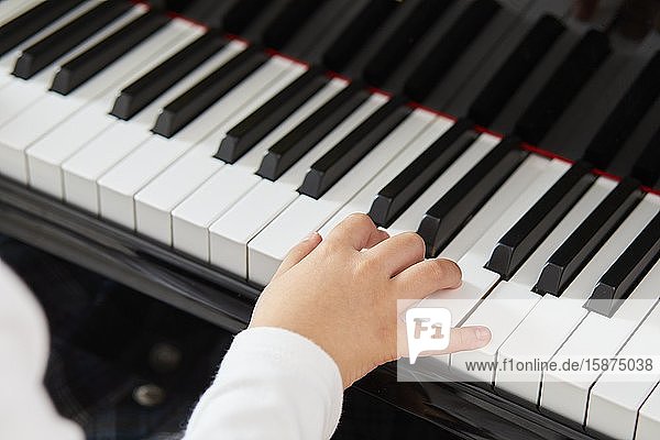 Japanisches Kind übt Klavier