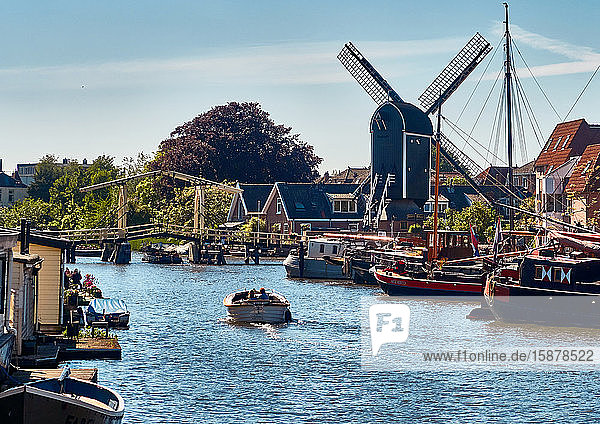 Stadt Leiden  Provinz Südholland  Niederlande  auf dem Galcewater-Kanal  einem Segelboot  das an der Straße Kort Galgewwaterr anlegt  und der Windmühle De Put   die auch als Rembrandts Windmühle bekannt ist. Die Stadt Leiden ist bekannt für ihre weltliche Architektur  ihre Grachten  ihre Universität von 1590  die Geburtsstadt von Rembrand  die Stadt  in der im 16. Jahrhundert die erste Tulpe Europas blühte.