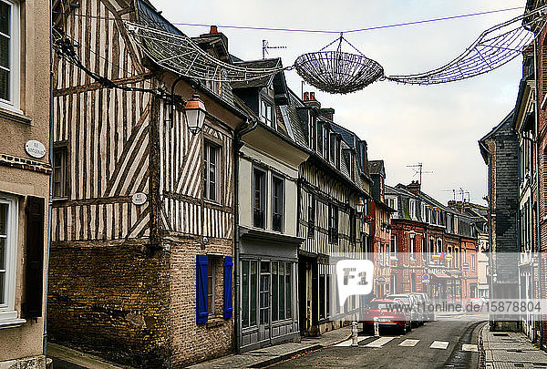 Typische normannische Fachwerkhäuser in der Stadt Honfleur in der Normandie. Die Stadt war ein beliebtes Ziel vieler Künstler und des Musikers Erik Satie und erfreut sich heute eines florierenden Sommertourismus  der von den Freiluftmärkten  der Kultur  den Cafés und der historischen Architektur angezogen wird.