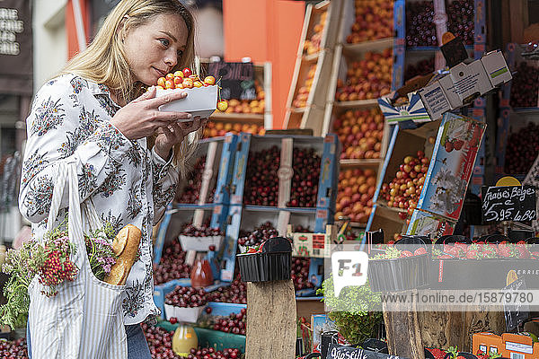 Junge Frau kauft Früchte an einem Marktstand