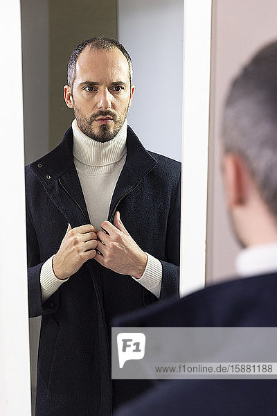Ein Mann  der sich im Spiegel betrachtet  um Selbstvertrauen zu gewinnen.