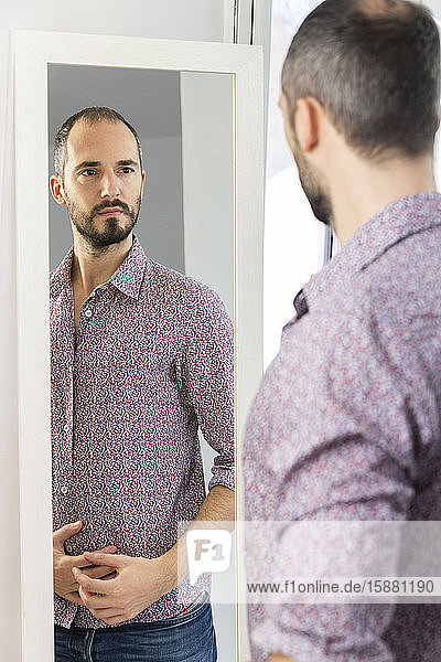 A man looking in a mirror to give him self-confidence.