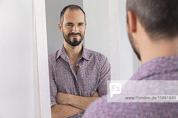 Ein Mann  der in einen Spiegel schaut  um sein Selbstvertrauen zu stärken.