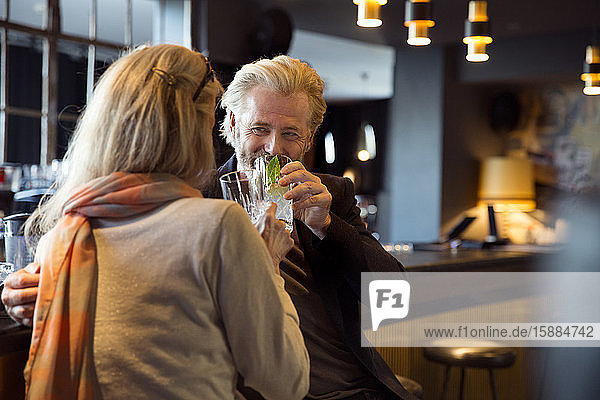 Close up of a couple enjoying a drink at a bar.