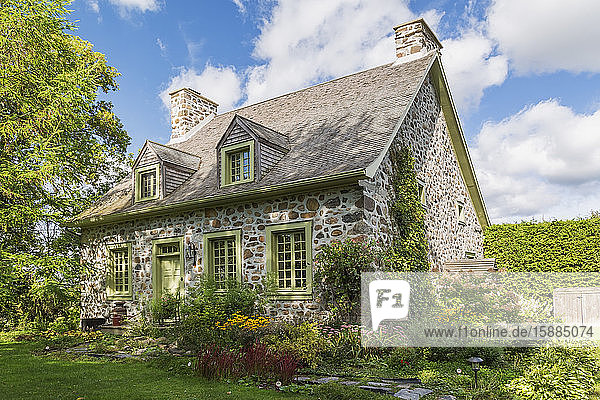 Außenansicht eines idyllischen Steinhauses mit hübschem Garten in Kanada.