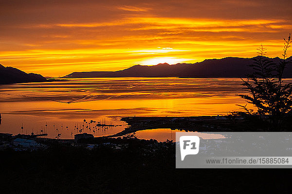 Sunset over the bay with mountains on the horizon.