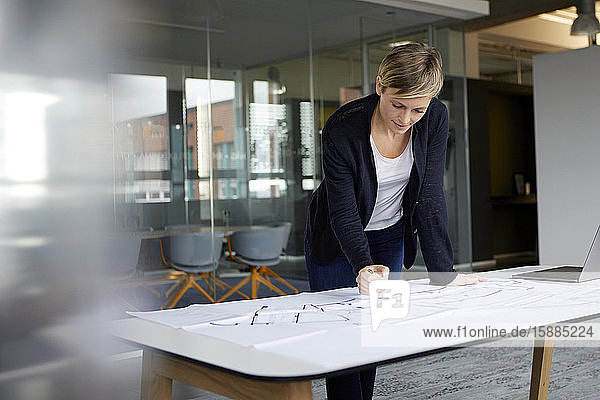 Woman working on construction plan in office