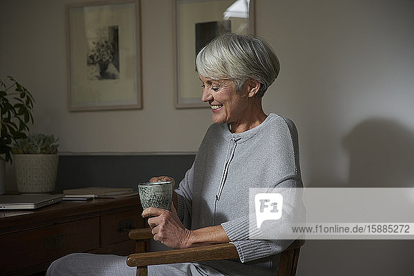 Ältere Frau entspannt sich bei einer Tasse Tee zu Hause