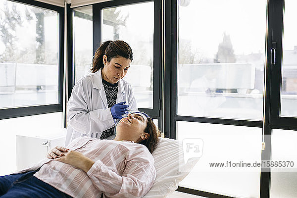 Frau erhält Botox-Injektion in der medizinischen Praxis