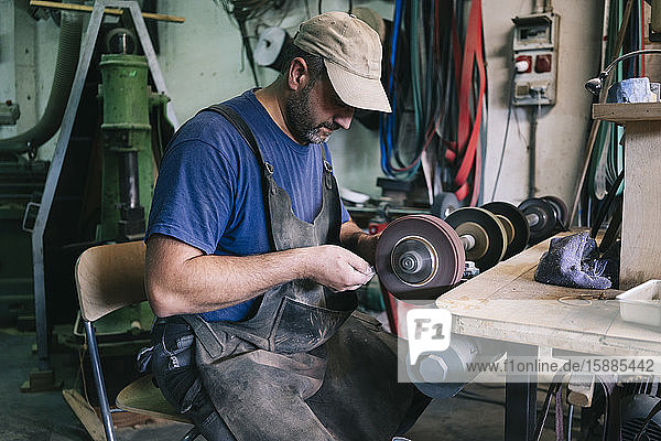 Handwerker  der in seiner Werkstatt Messer herstellt