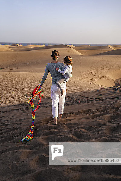 Mutter und Tochter gehen mit einem Drachen in den Sanddünen  Gran Canaria  Spanien