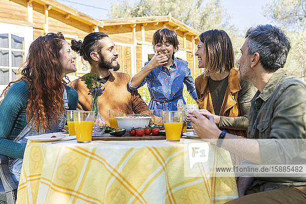 Fanily und Freunde genießen ein gesundes veganes Frühstück auf dem Land