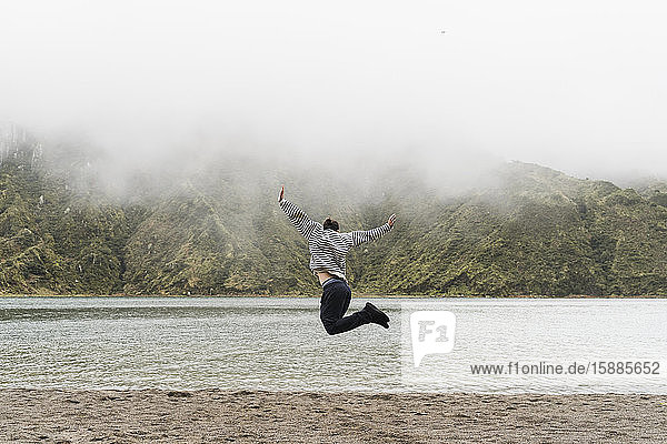 Ein Mann springt in voller Länge in die Luft  während er auf der Insel Sao Miguel  Azoren  Portugal  Urlaub macht.