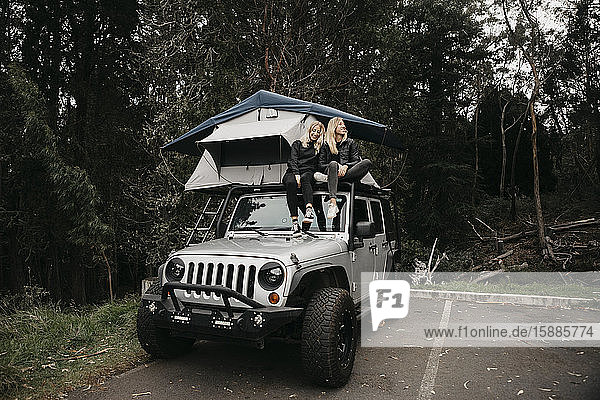 Glückliche Freundinnen sitzen im Zelt über einem Jeep im Haleakala-Nationalpark  Maui  Hawaii  USA