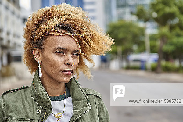 Portrait of a young woman with afro hairstyle in the city