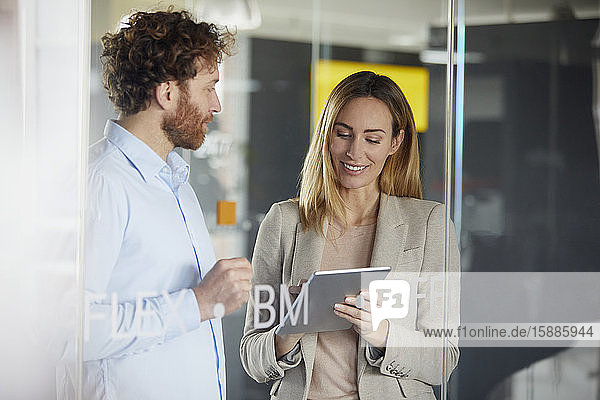 Businessman and businesswoman working together with tablet in office