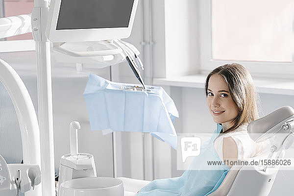 Zuversichtliche junge Frau wartet auf Behandlung in Zahnklinik