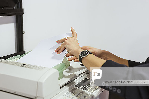 Nahaufnahme einer Geschäftsfrau  die im Büro Papiere vom Drucker nimmt