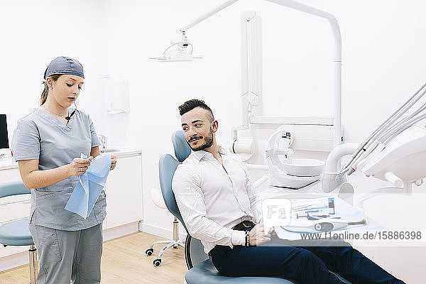 Medizinischer Sekretär bereitet Zahnbehandlung für Patient vor
