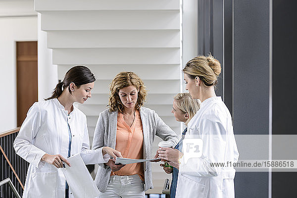 Geschäftsfrau und Ärztinnen bei einer Arbeitsbesprechung im Krankenhaus