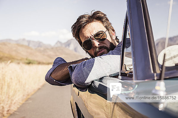 Portrait of man in convertible car on a road trip