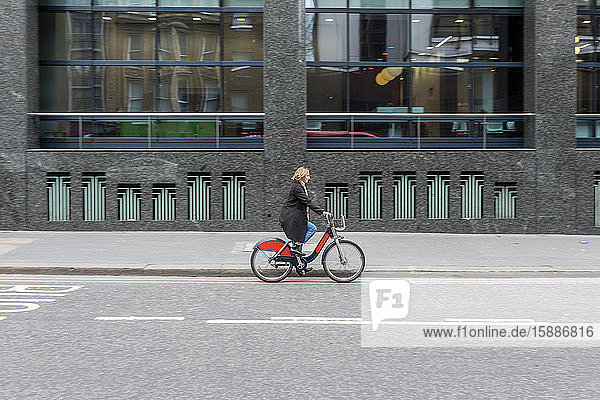Woman riding bicycle in the city  London  UK