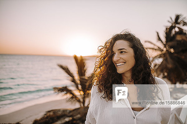 Frau genießt Sonnenaufgang am Meer