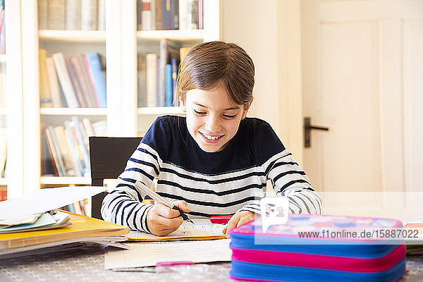Portrait of smiling girl doing homework