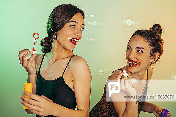 Porträt von zwei Freunden  die sich mit Seifenblasen vergnügen