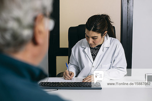 Arzt macht Notizen während einer Konsultation in der medizinischen Praxis